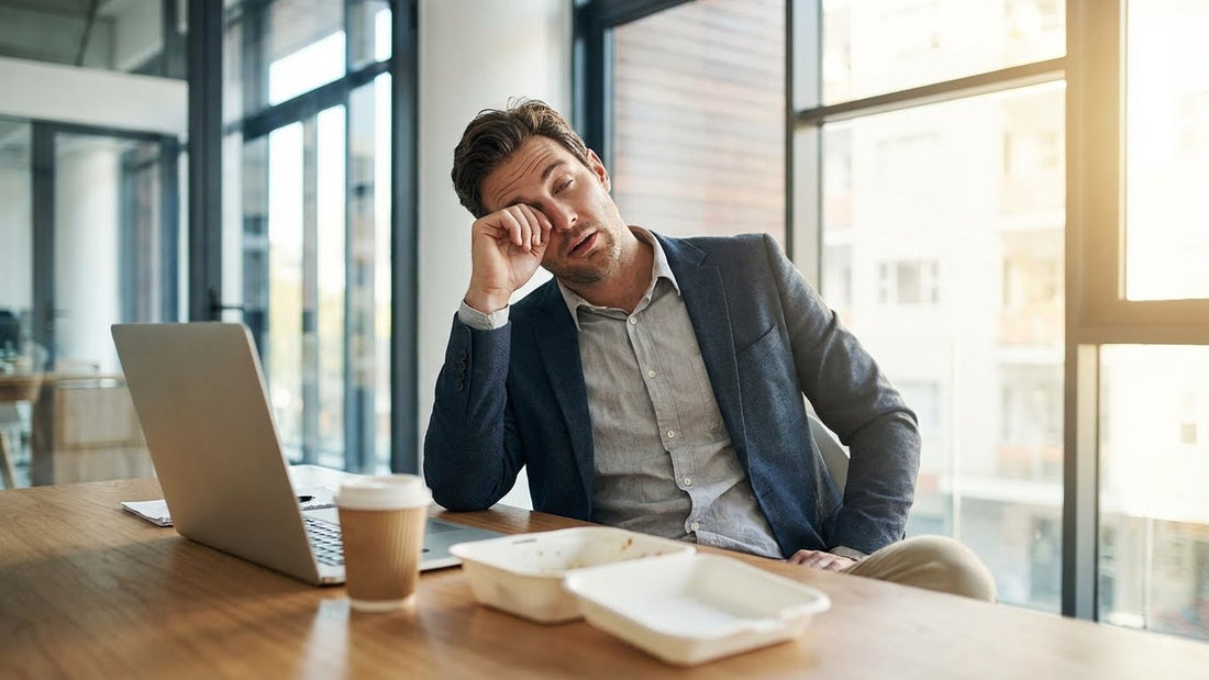 man feeling sleepy after lunch while working at a desk